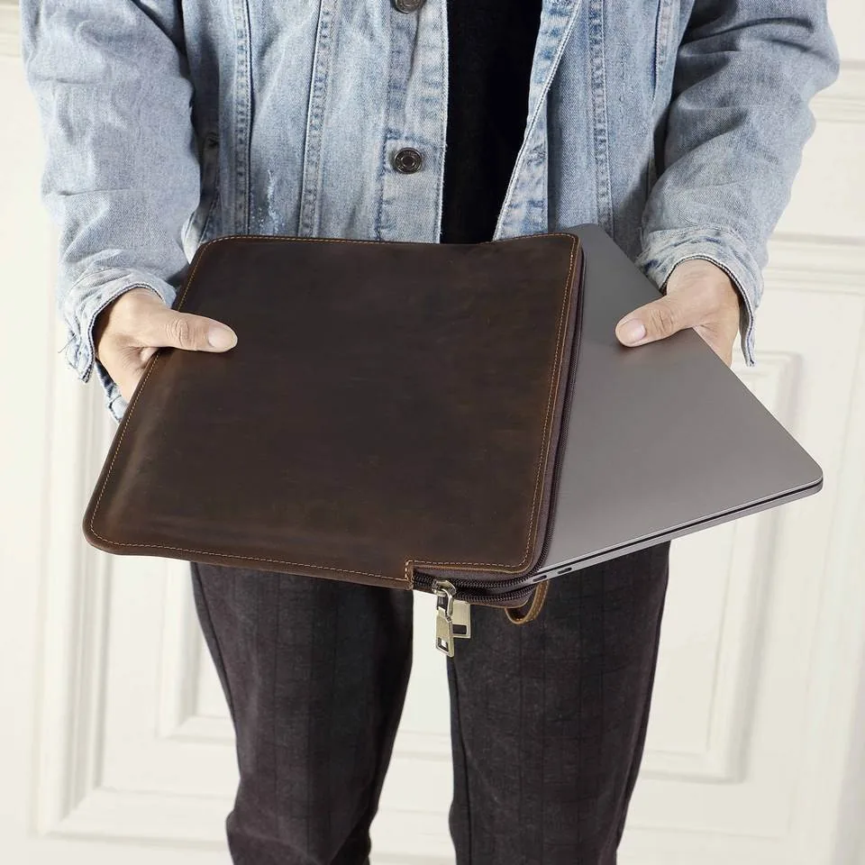 Leather laptop sleeve shown with a laptop partially inserted
